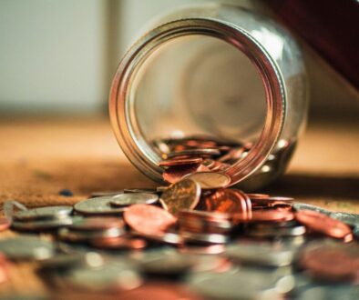 glass jar spilling coins onto table
