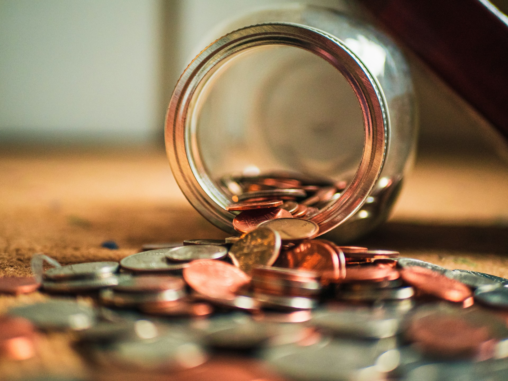 glass jar spilling coins onto table